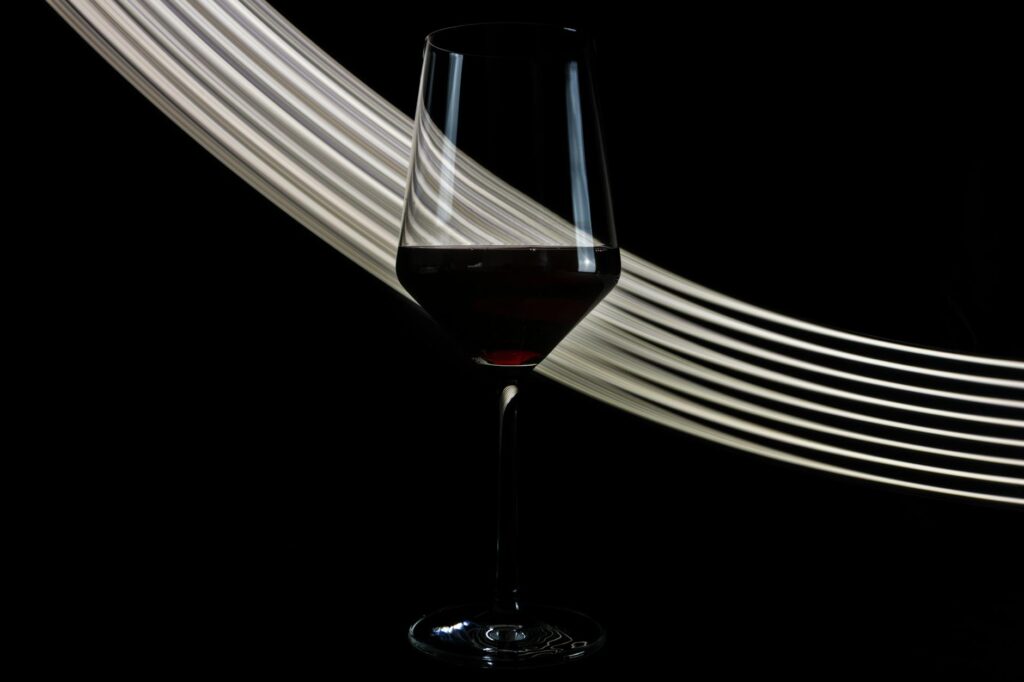 wineglass of fine red wine on black background