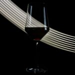 wineglass of fine red wine on black background